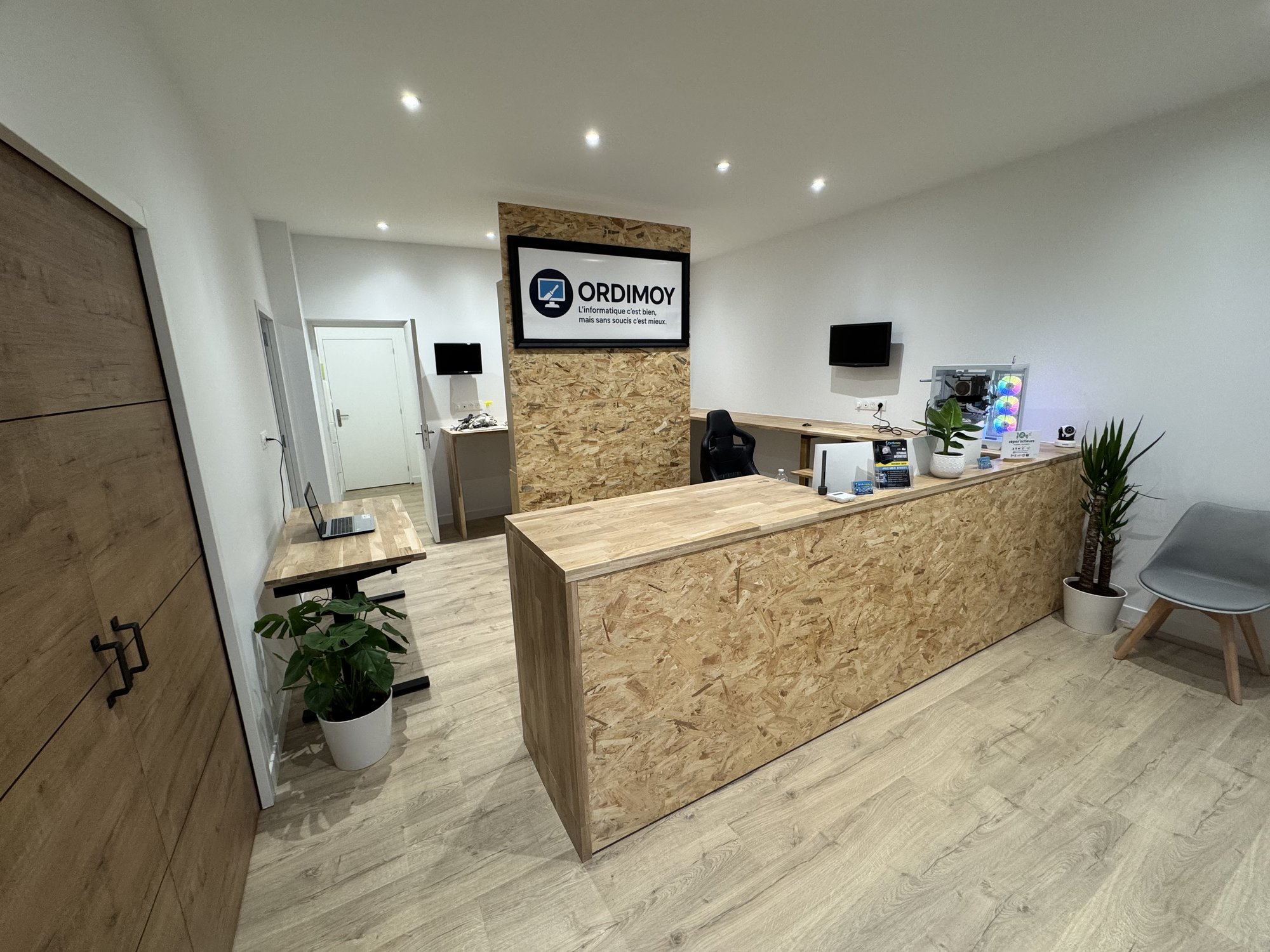 Intérieur de l'atelier Ordimoy : comptoir d'accueil en OSB et espace de réception lumineux
